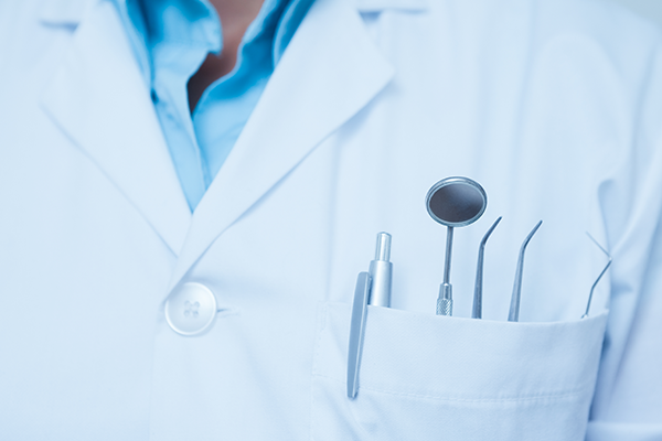 dental professional with dental instruments