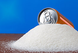 Can of soda atop a mound of granulated sugar