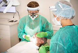 Dentists in PPE caring for a male patient