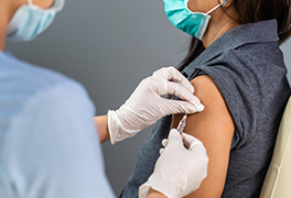 Woman receiving a vaccination from a health care worker